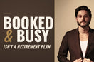 Barber and educator Tyler Carlson in a chocolate-brown suit jacket against a tan studio backdrop, beside the words Booked and Busy Isn’t a Retirement Plan on a chocolate-brown field.