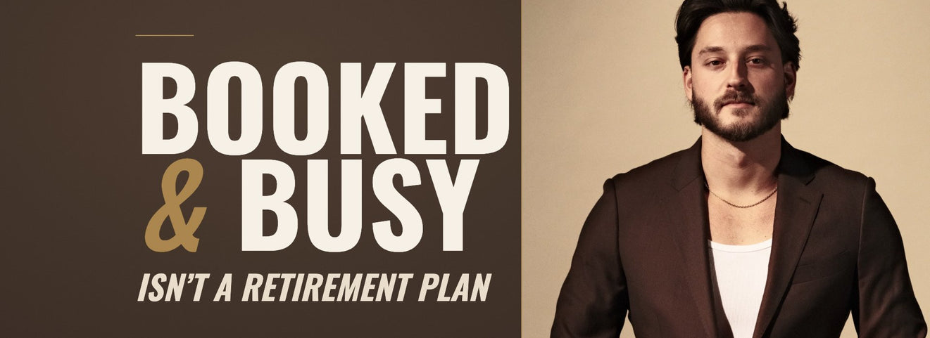 Barber and educator Tyler Carlson in a chocolate-brown suit jacket against a tan studio backdrop, beside the words Booked and Busy Isn’t a Retirement Plan on a chocolate-brown field.